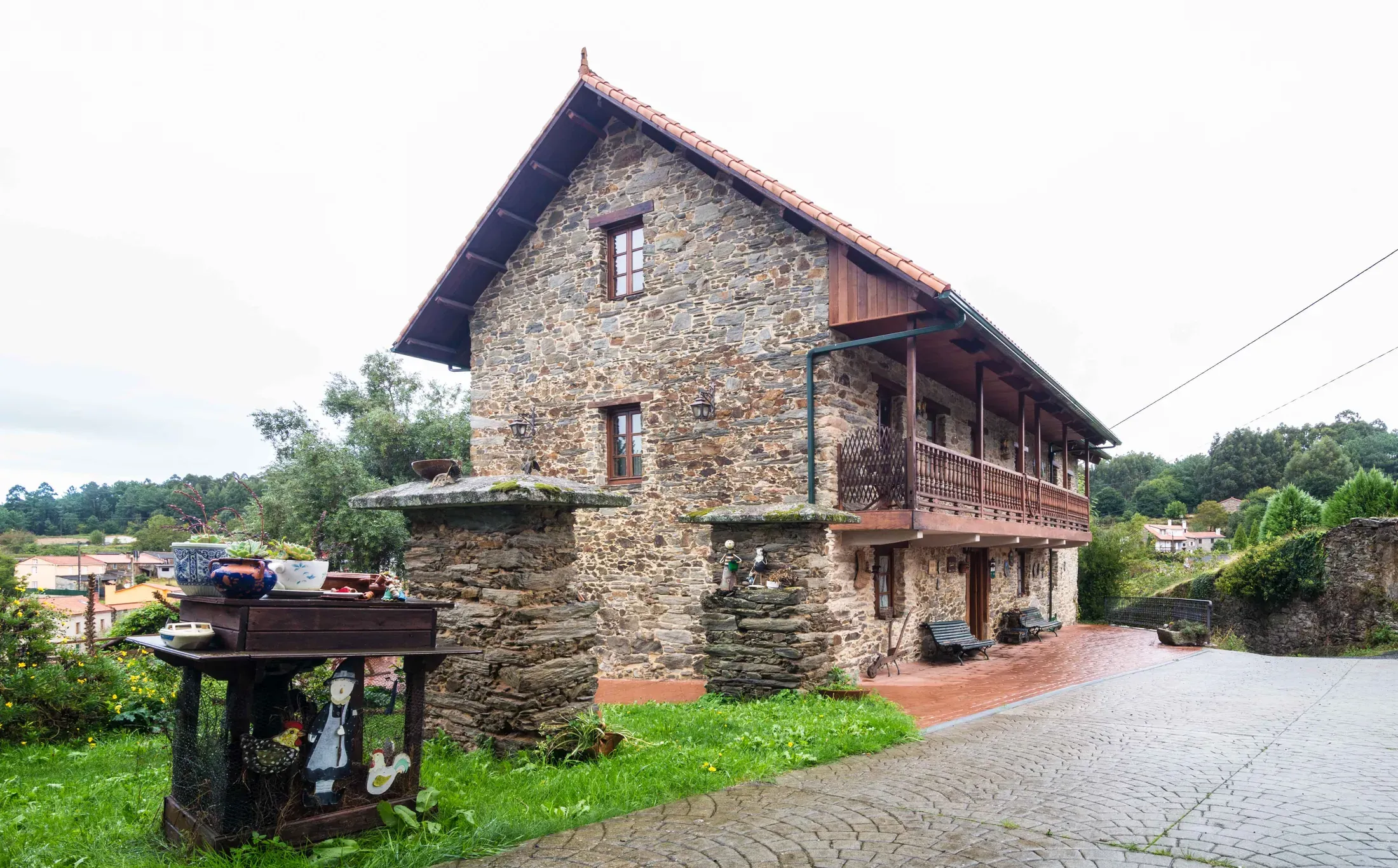 Side view of the house with its wooden gallery and carport