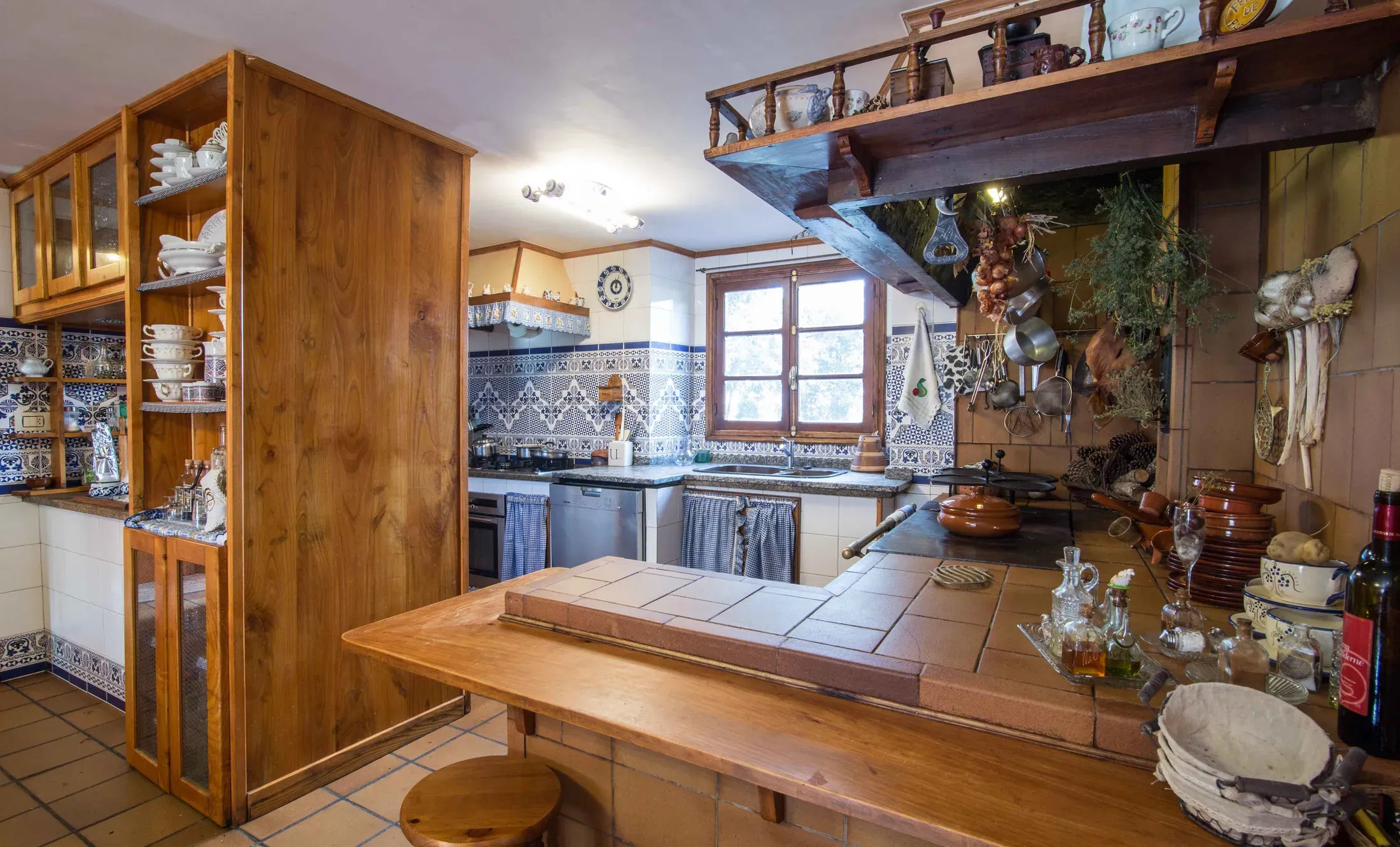 Rustic wooden kitchen with tiled walls and a stone worktop