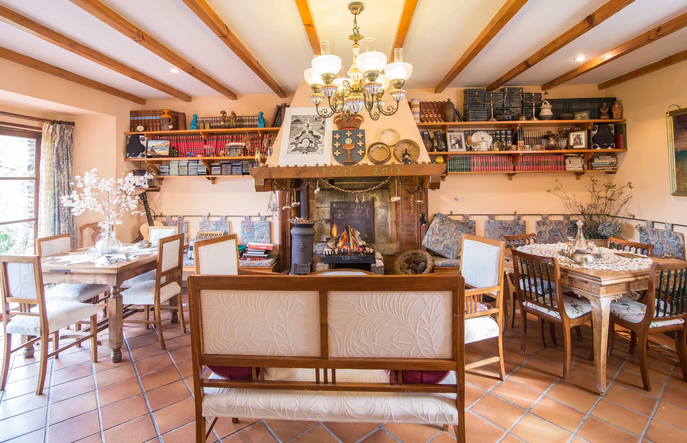 Living room with a stone fireplace, a chandelier and crockery shelves